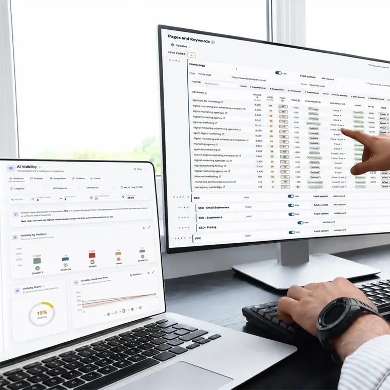 SEO specialist reviewing keyword rankings and AI visibility data across desktop and laptop screens.