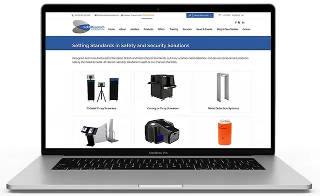 MacBook Pro displaying the Todd Research website's ecommerce product grid, showcasing security equipment like X-ray scanners, metal detection systems, and containment devices, all presented on a clean white background.