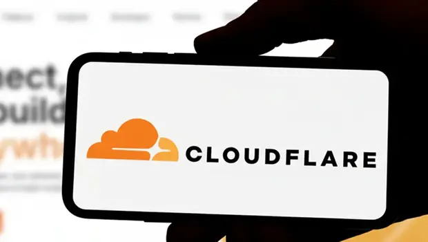 Cloudflare logo on a smartphone in front of the website, used to illustrate our latest news update on the recent Cloudflare outage.