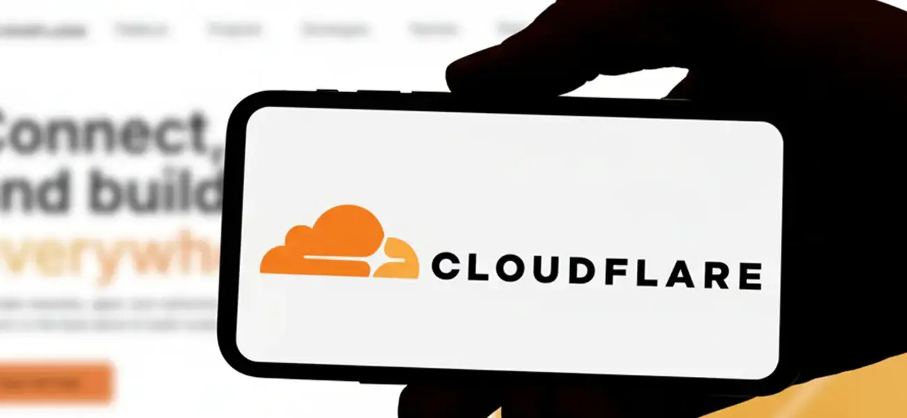 Cloudflare logo on a smartphone in front of the website, used to illustrate our latest news update on the recent Cloudflare outage.
