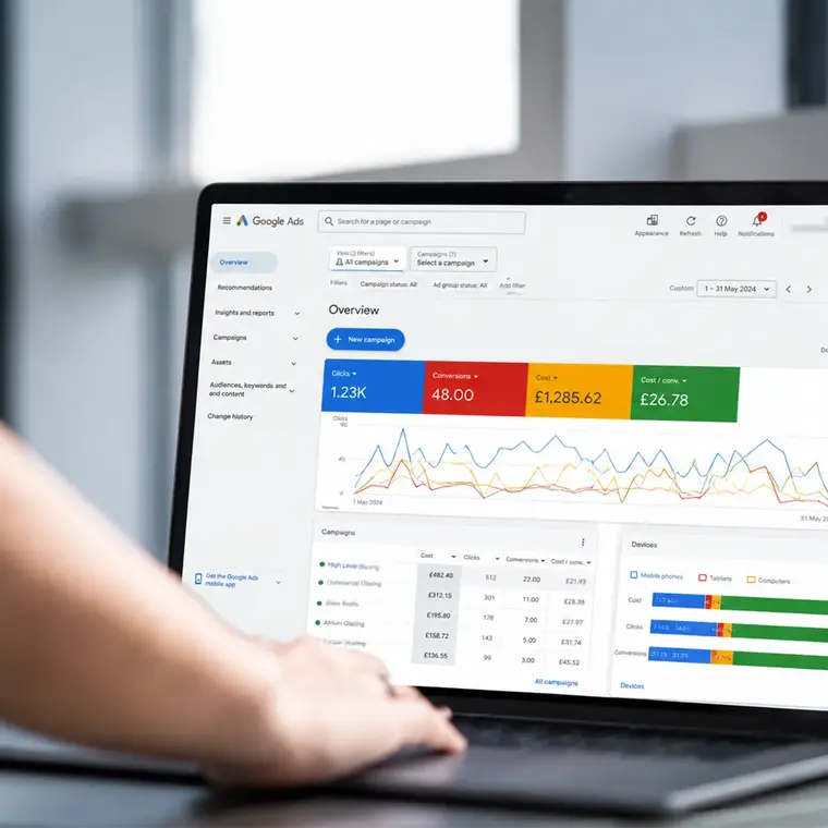 Google Ads dashboard on a laptop displaying PPC campaign clicks, conversions, costs and performance data.