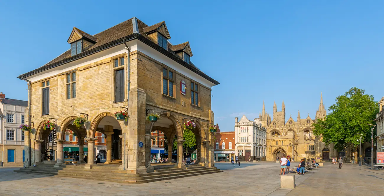 Cathedral Square in Peterborough city centre with the Guildhall, historic buildings and Peterborough Cathedral on a clear summer day.